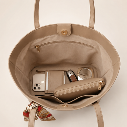 Beige handbag with items including a phone and wallet on a beige background