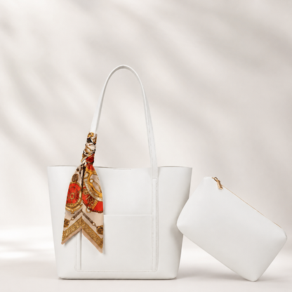 White handbag with a colorful scarf draped over it on a light background