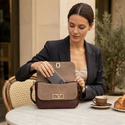 Woman in a professional setting opening a brown handbag with a blurred background