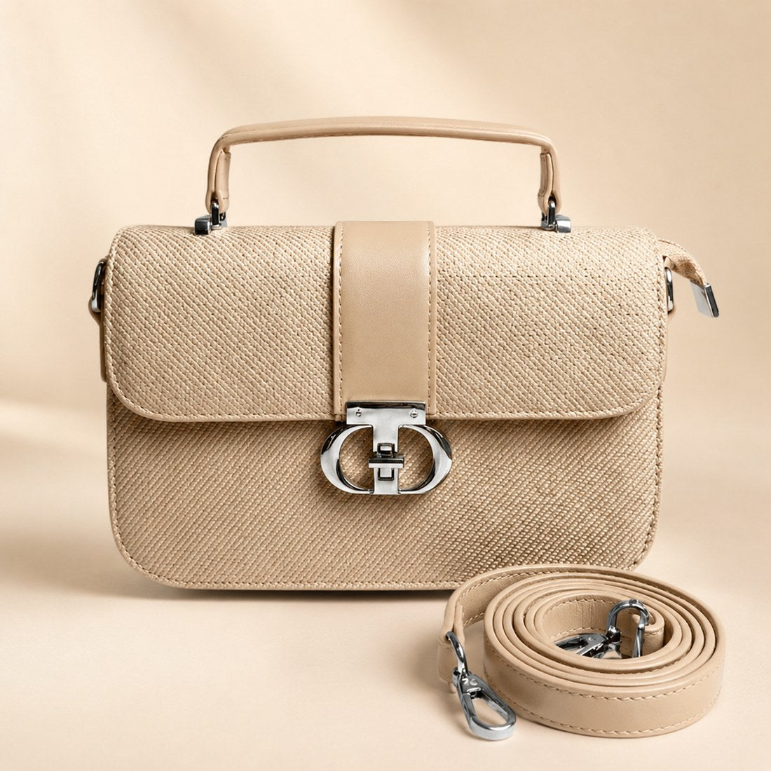 Beige handbag with matching strap on a beige background