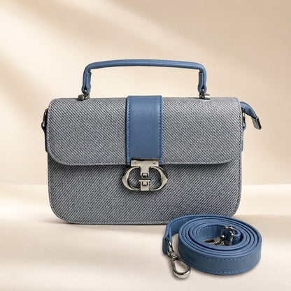 Gray handbag with blue strap and matching detachable strap on a beige background