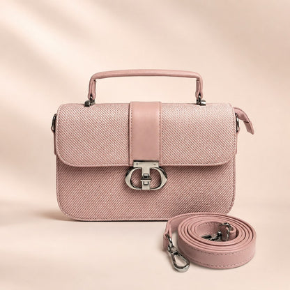 Pink handbag with matching strap on a light pink background