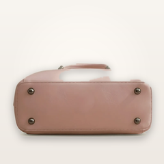 Pink handbag with metallic studs on a light gray background